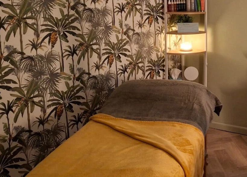 Relaxing treatment room at Blubell Nails and Beauty, Rode Heath, England, GB, with tropical wallpaper and cozy bed.