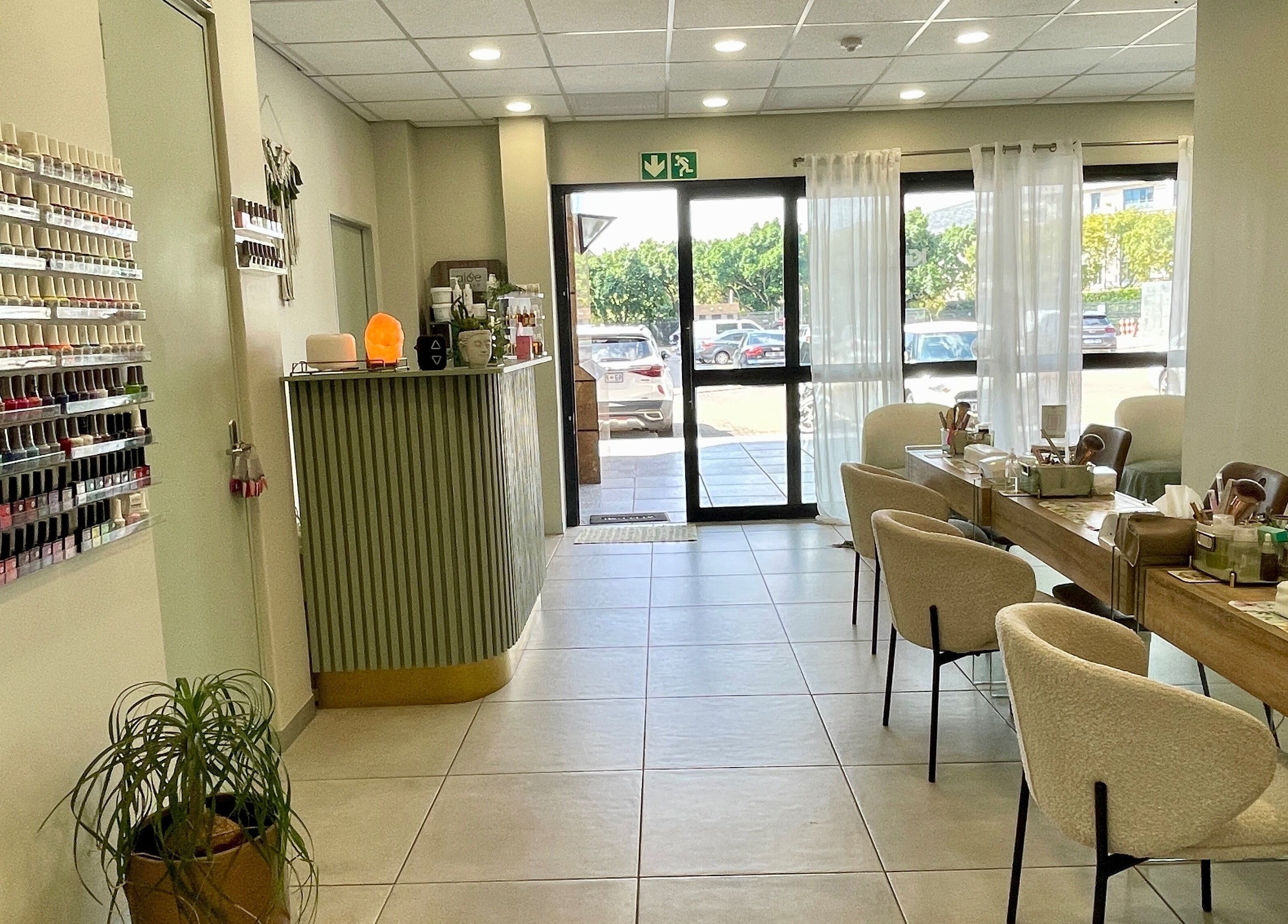 Interior of KimCo Beauty Lab, Sandton, Gauteng, ZA, featuring nail polish display and comfy seating.