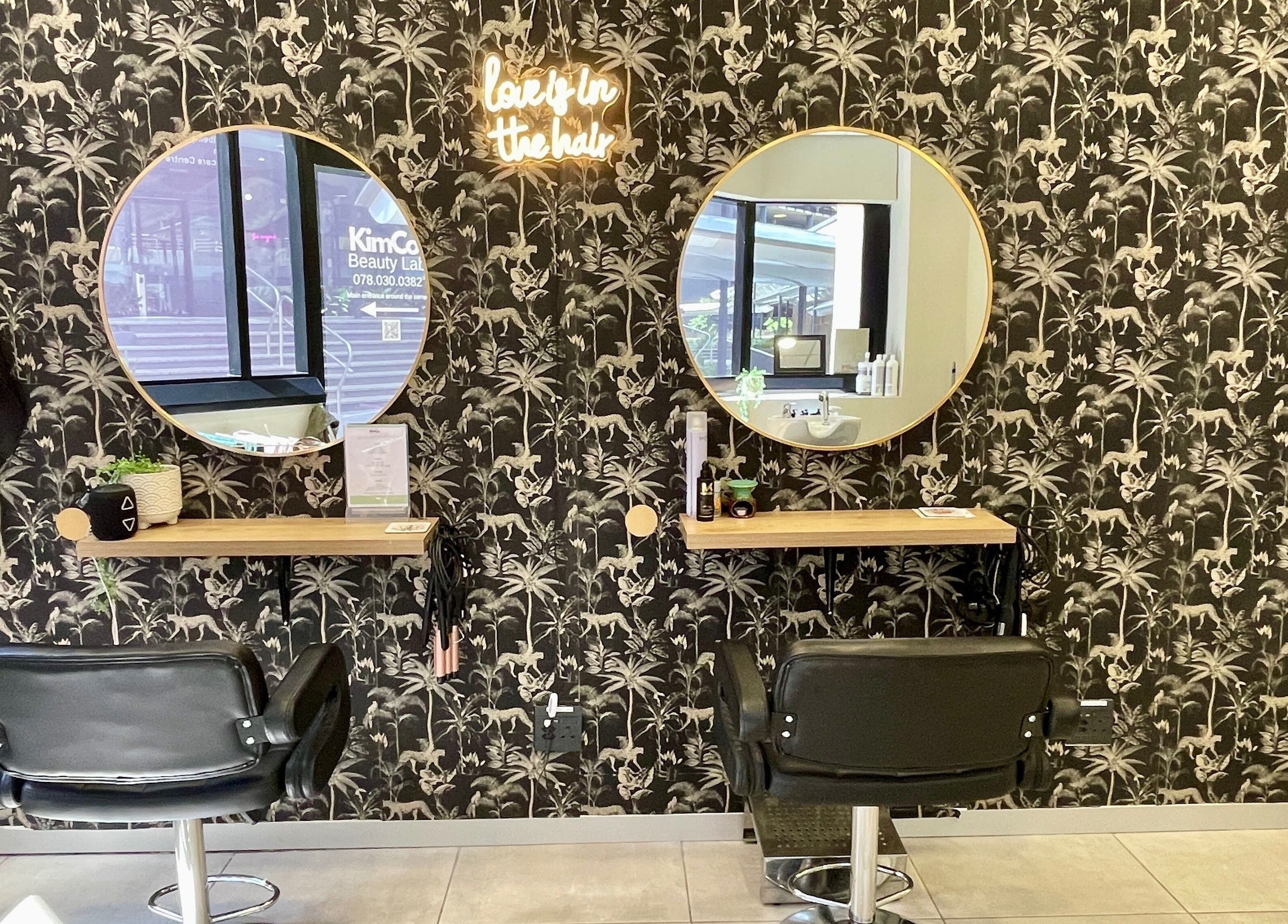 Chic salon interior at KimCo Beauty Lab, Sandton, Gauteng, ZA, featuring elegant mirrors and styling chairs.