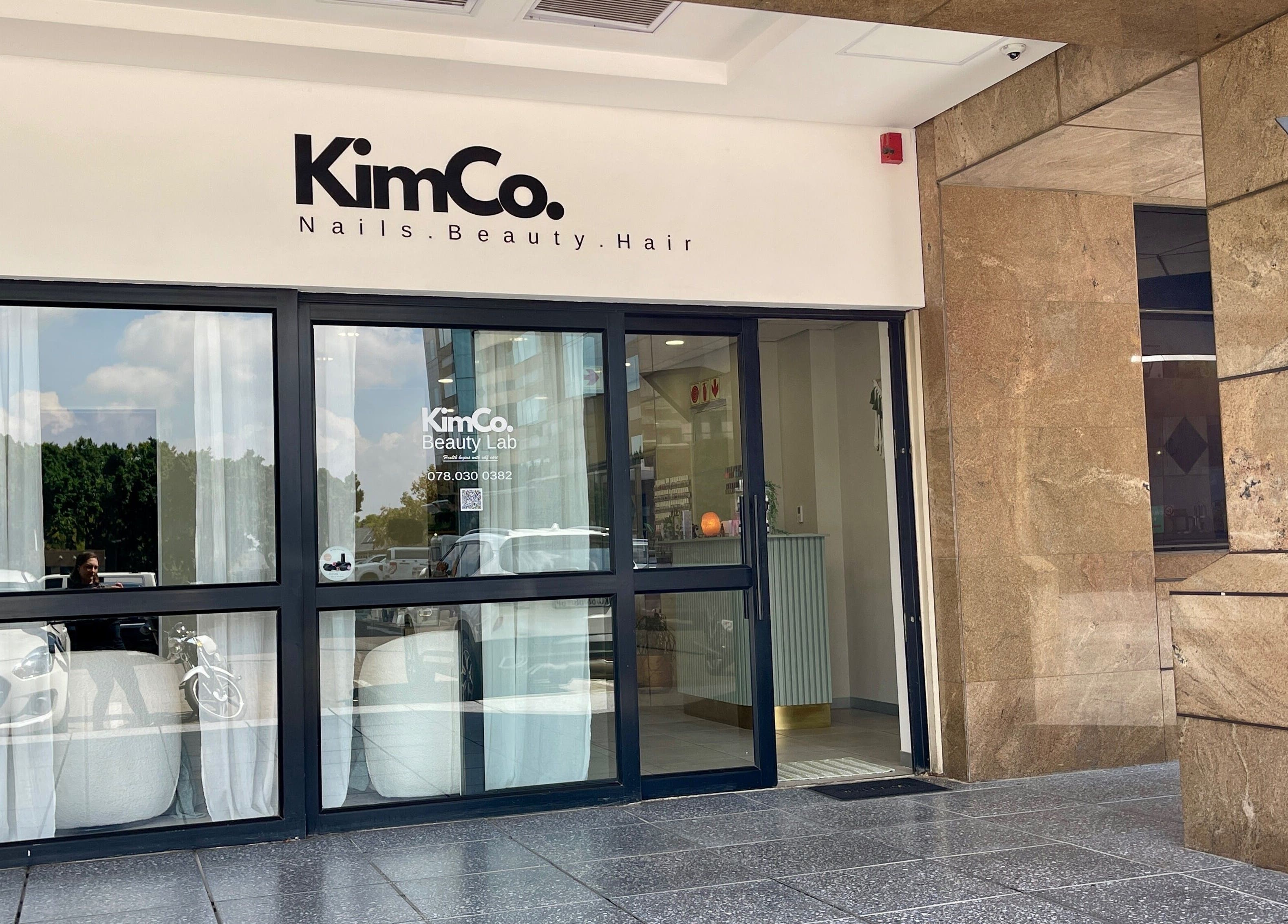 Front view of KimCo Beauty Lab in Sandton, Gauteng, ZA, showcasing elegant glass doors and inviting atmosphere.