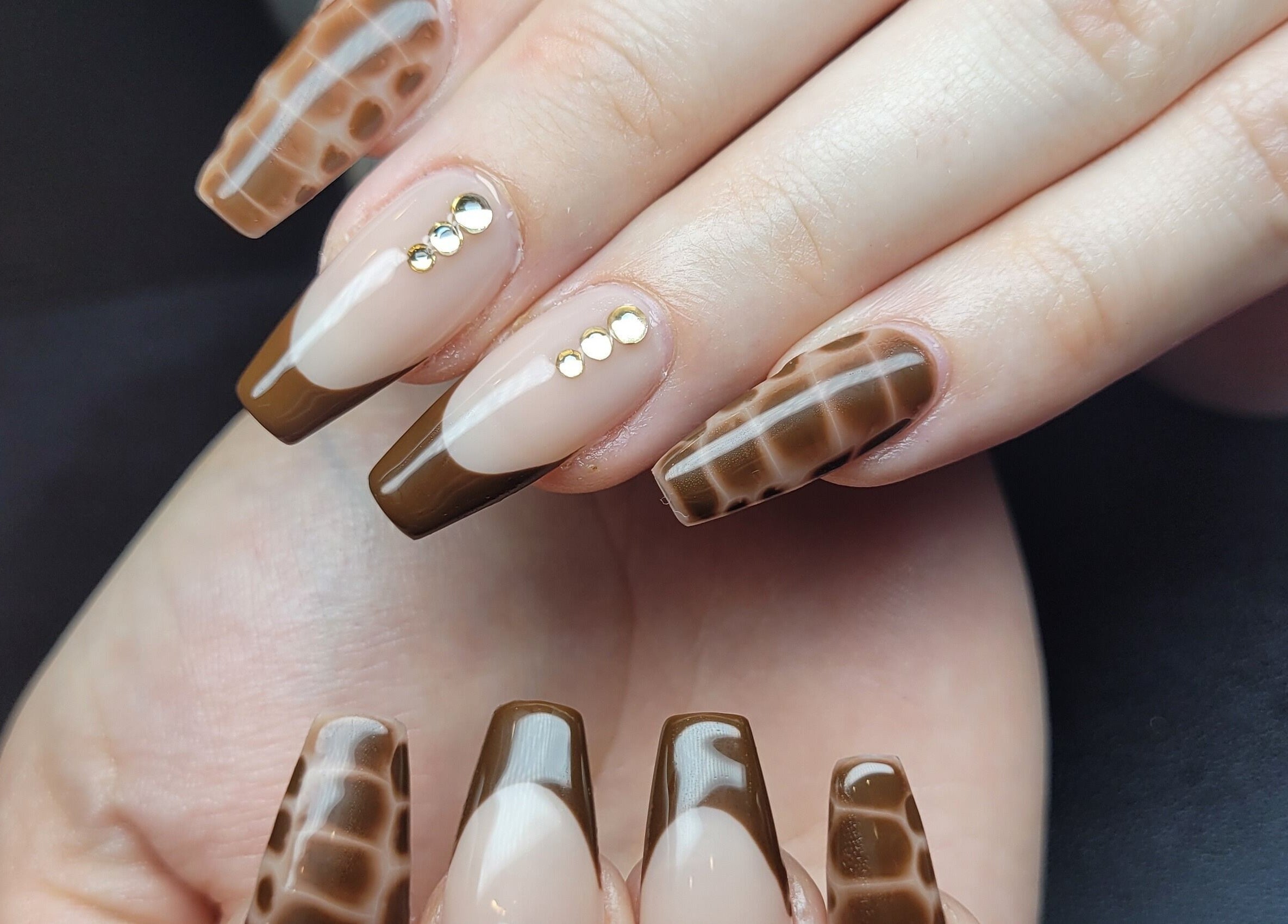 Stylish brown nail art with stones at Hardcorr Nails, Zimmerman, Minnesota, US.