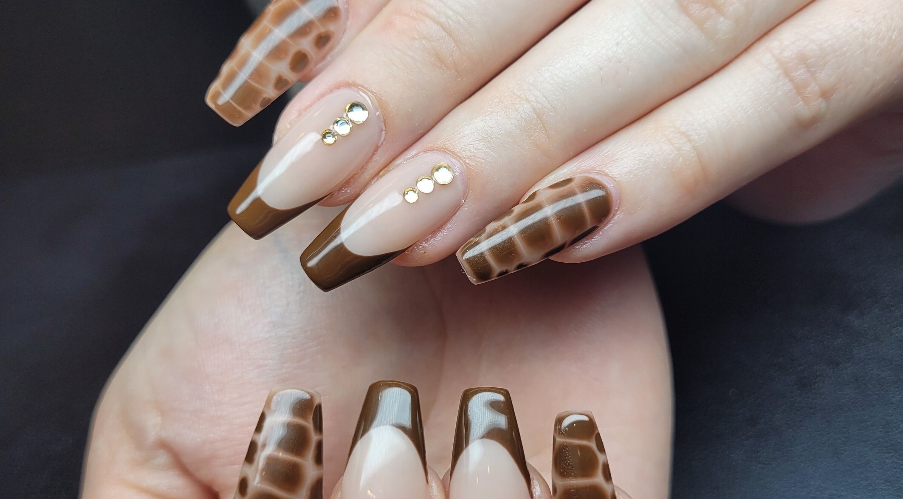 Stylish brown nail art with stones at Hardcorr Nails, Zimmerman, Minnesota, US.