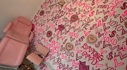 Vibrant therapy room at Beauty and Aesthetics Lodge, London Colney, England, GB, with pink decor and chic wall art.