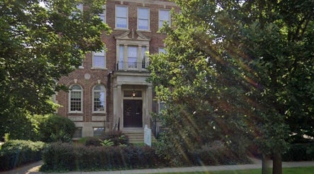 Charming brick facade of New Beginnings Spa Services in Lansing, Michigan, US surrounded by lush greenery.