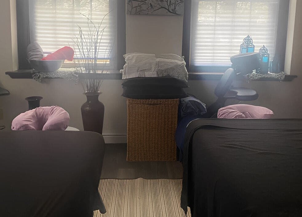 Peaceful massage room at New Beginnings Spa Services in Lansing, Michigan, US, highlighted by soft lighting.