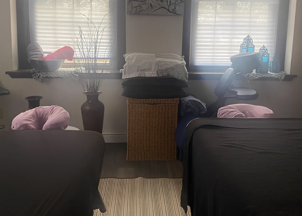 Peaceful massage room at New Beginnings Spa Services in Lansing, Michigan, US, highlighted by soft lighting.