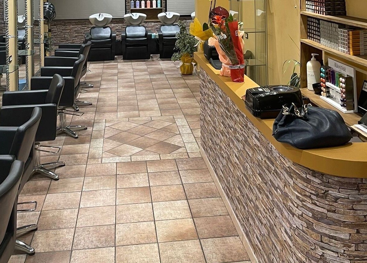 Interno elegante di Hair Masters by Davide Ginestra ad Albano Laziale, Lazio, IT, con poltrone moderne e prodotti di bellezza.