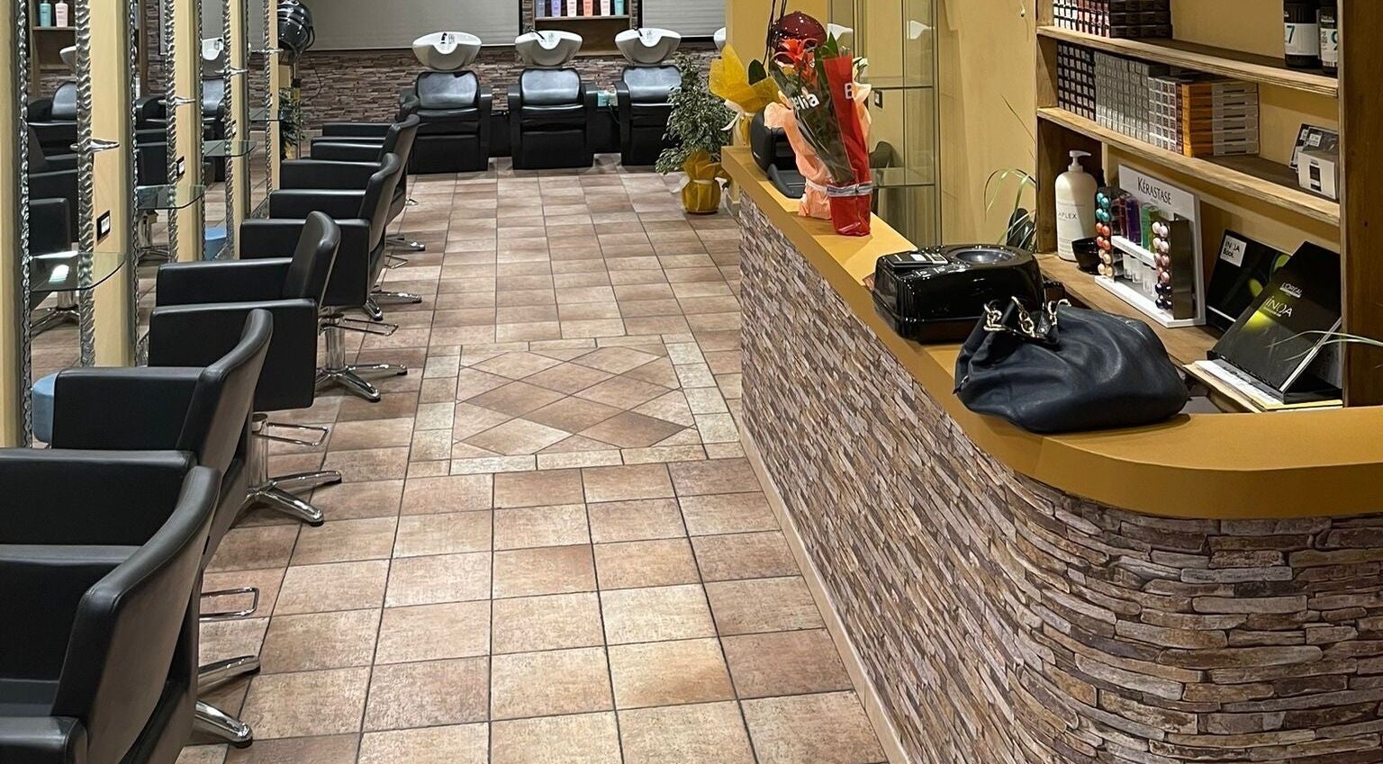 Interno elegante di Hair Masters by Davide Ginestra ad Albano Laziale, Lazio, IT, con poltrone moderne e prodotti di bellezza.