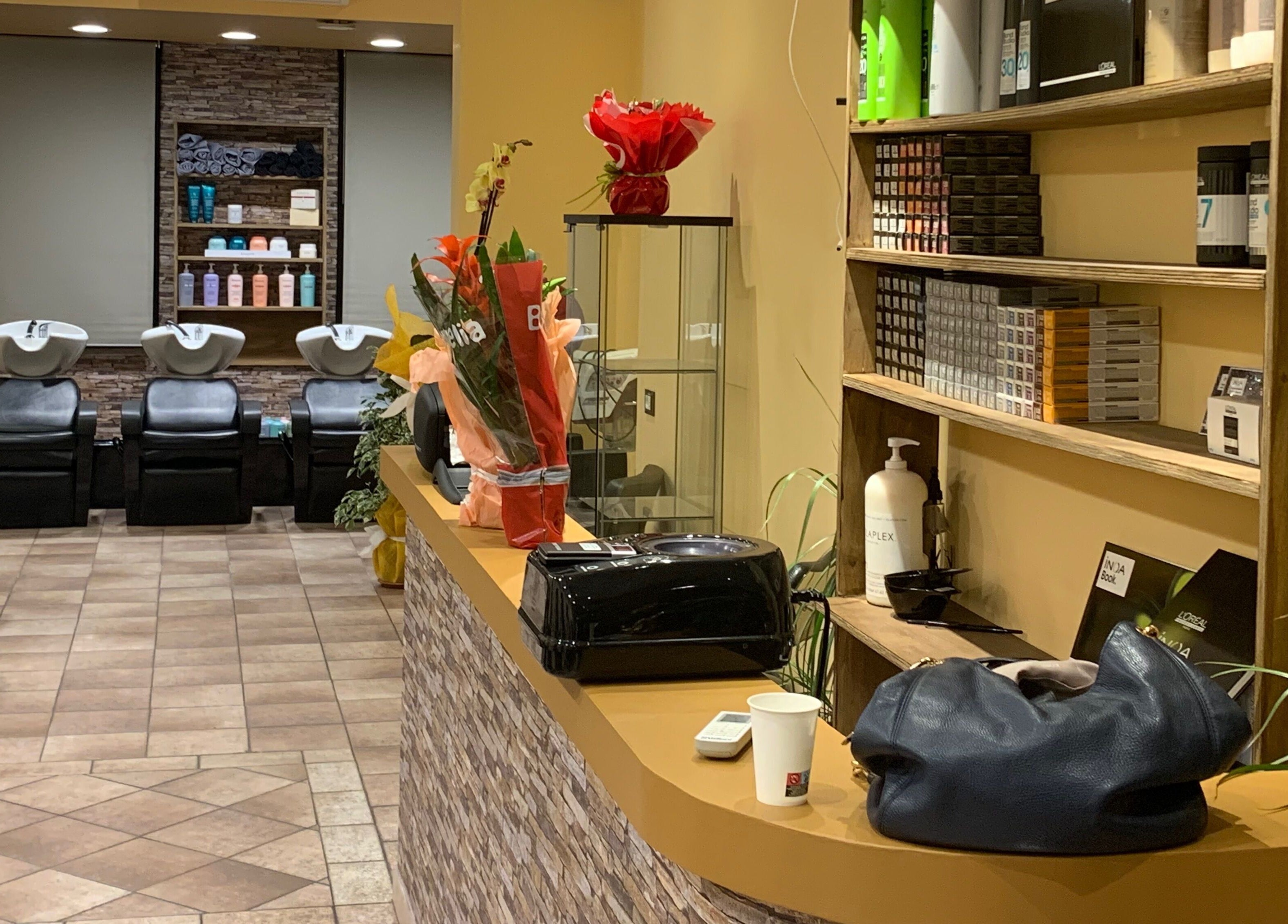 Interno elegante di Hair Masters by Davide Ginestra ad Albano Laziale, Lazio, IT con postazioni e prodotti ben visibili.