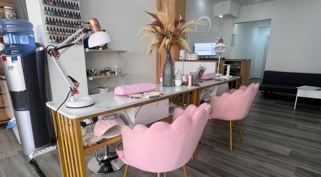 Nail salon interior at Cosmetic Island Port Louis with pink chairs, desk, and decor, Port Louis District, MU.