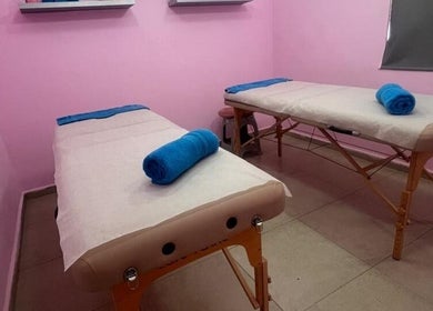 Serene massage room at Cosmetic Island Quatre Bornes, Plaines Wilhems District, MU with pink walls and relaxing beds.