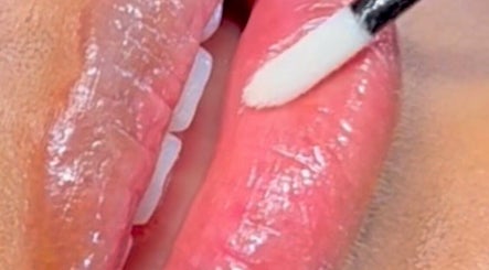Glossy lips being applied at Inv Beauty Bar, Toronto, Ontario, CA, showcasing expert beauty care.