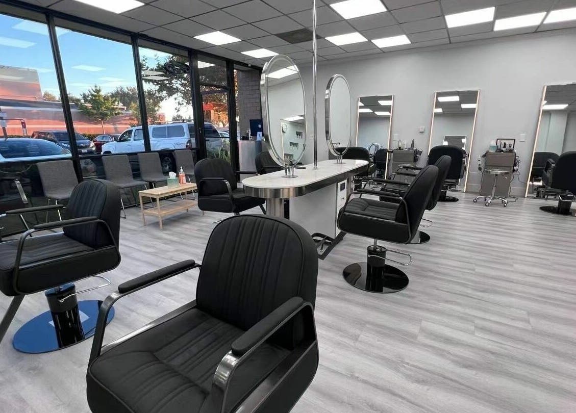 Modern interior of K MA Salon Convoy in San Diego, California, US with stylish black chairs and large mirrors.