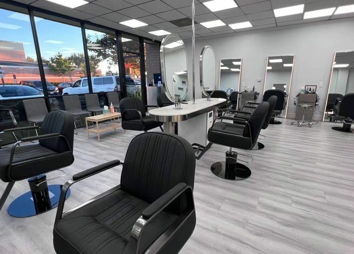 Modern interior of K MA Salon Convoy in San Diego, California, US with stylish black chairs and large mirrors.