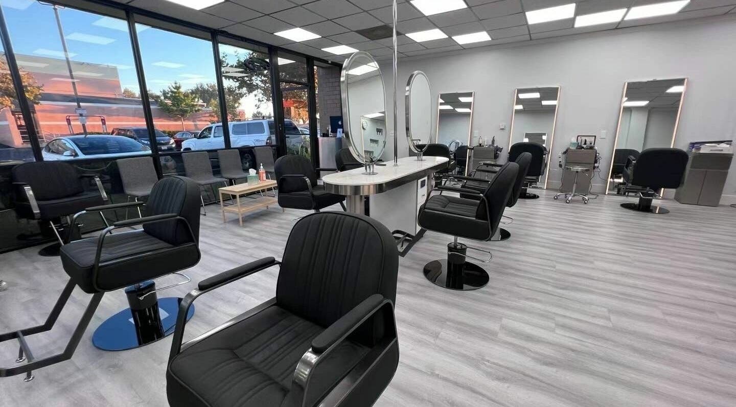 Modern interior of K MA Salon Convoy in San Diego, California, US with stylish black chairs and large mirrors.
