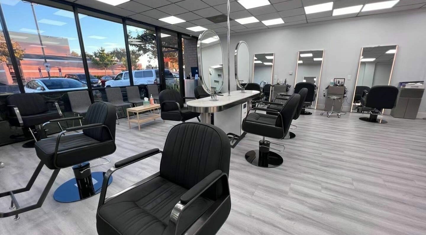 Modern interior of K MA Salon Convoy in San Diego, California, US with stylish black chairs and large mirrors.
