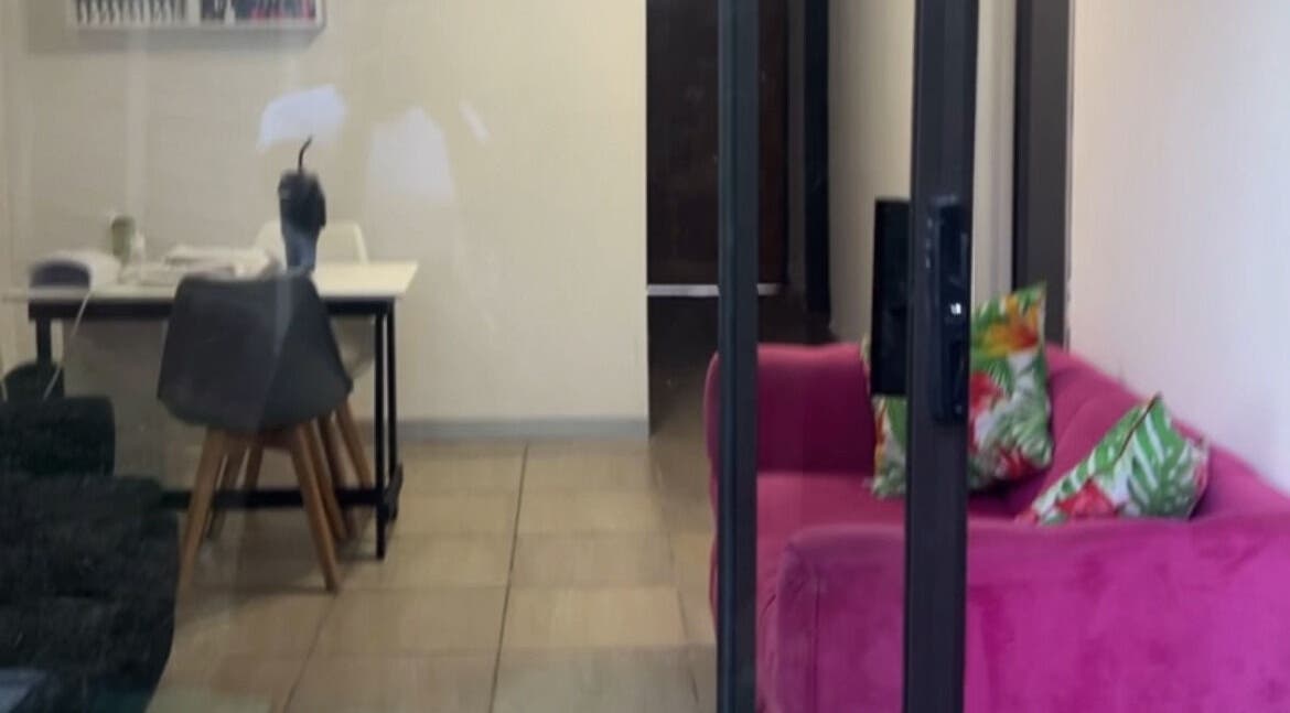Cozy lounge at Nails&Beauty by Busie, Johannesburg, Gauteng, ZA featuring vibrant pink sofa and stylish decor.