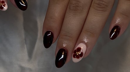 Stylish floral nail art at CW and Co, Melbourne, Victoria, AU. Dark red polish with a delicate flower design.