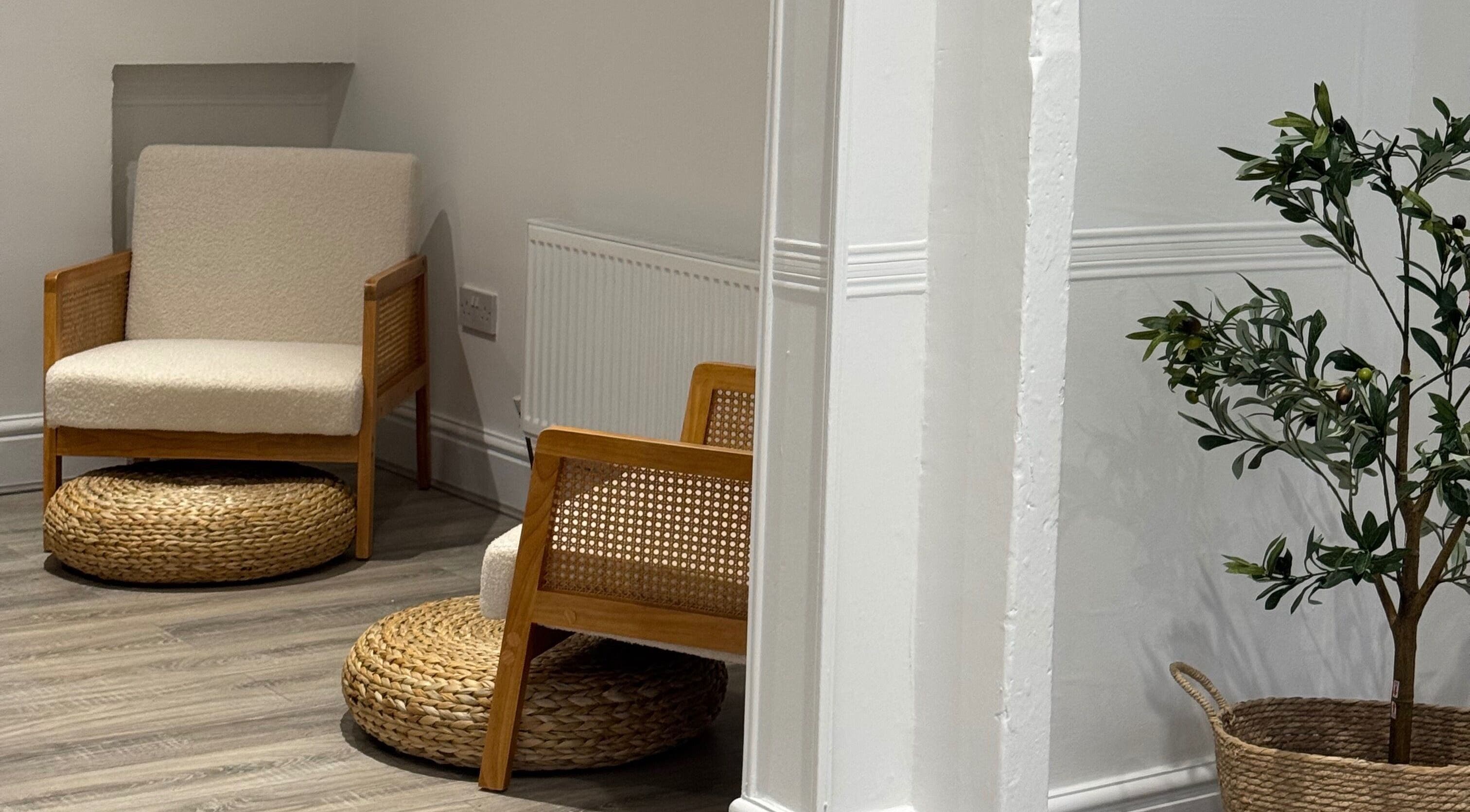 Cozy seating area at calma salons - Lymm with wicker chairs and potted plant. Lymm, England, GB.