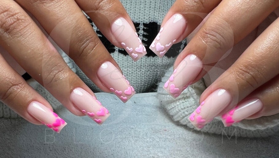 Stylish pink heart nail art at Cherry Blossom, Gönyeli, TR, showcasing intricate manicure design.