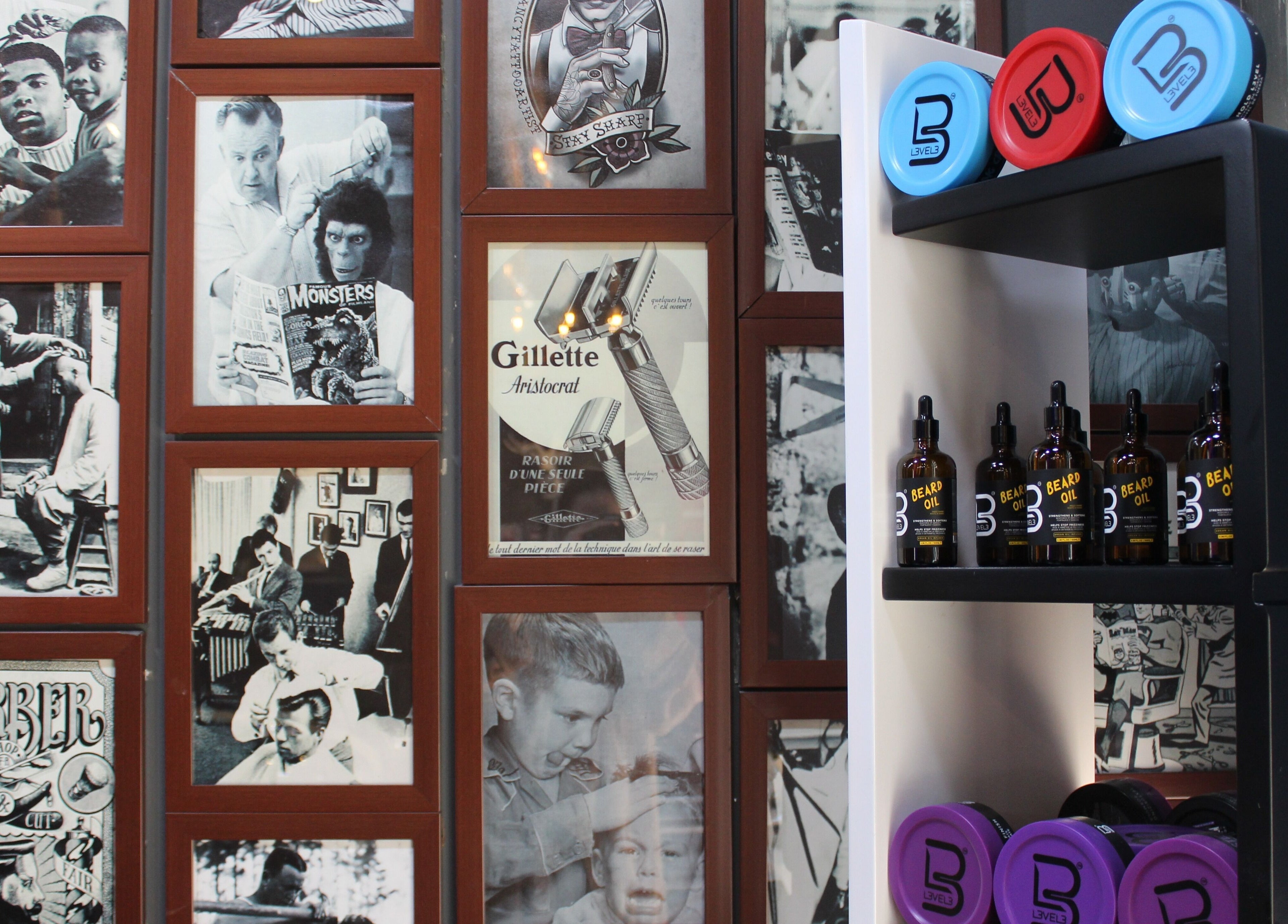 Wall of vintage barber photos with grooming products at Black Level Gent's Salon, Dubai, Dubai, AE.