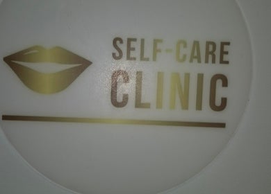 Self Care Clinic logo in gold with lips icon at Porth, Wales, GB.