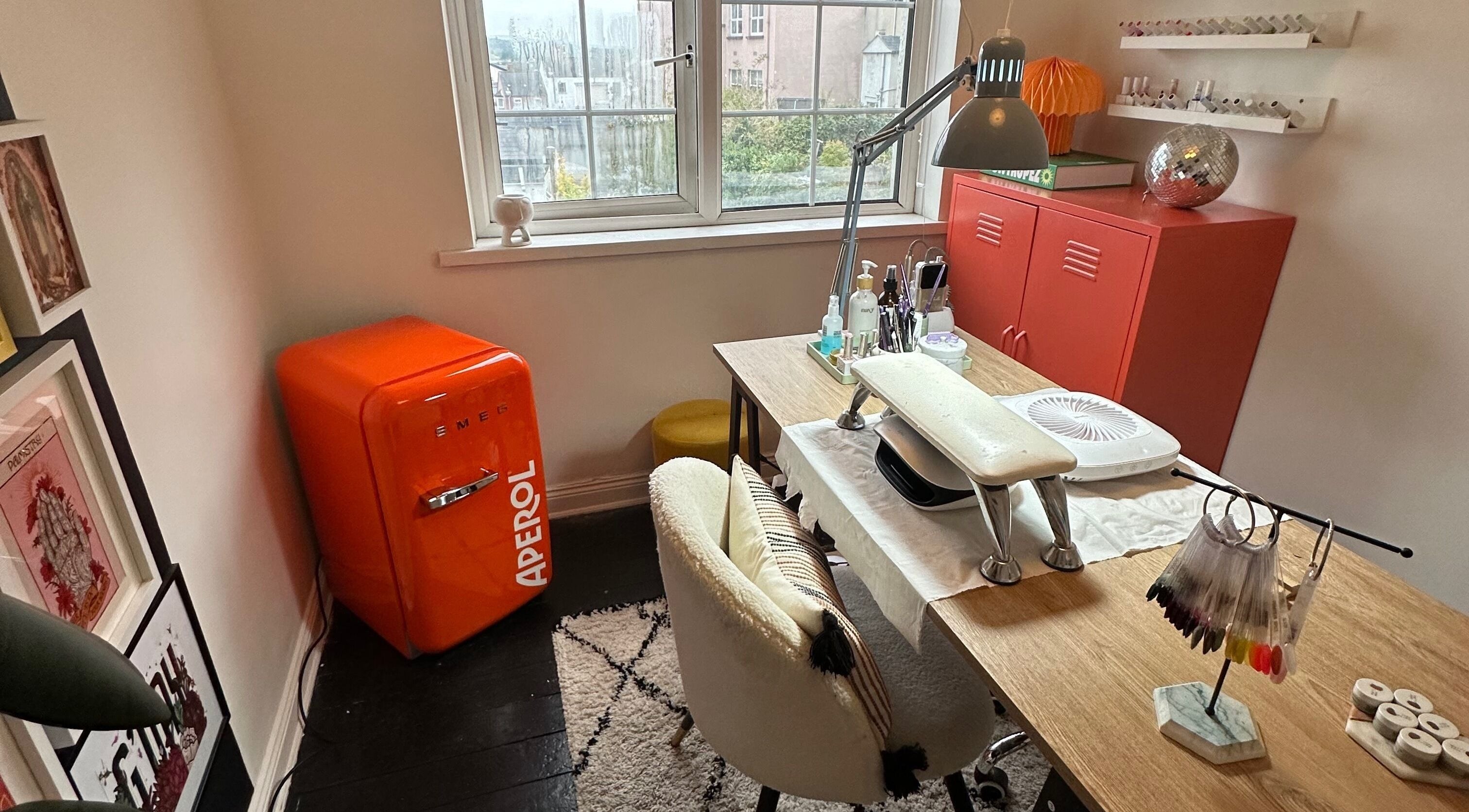 Chic nail workstation at Studio 65 in Londonderry, Northern Ireland, GB, featuring a vibrant orange mini-fridge.