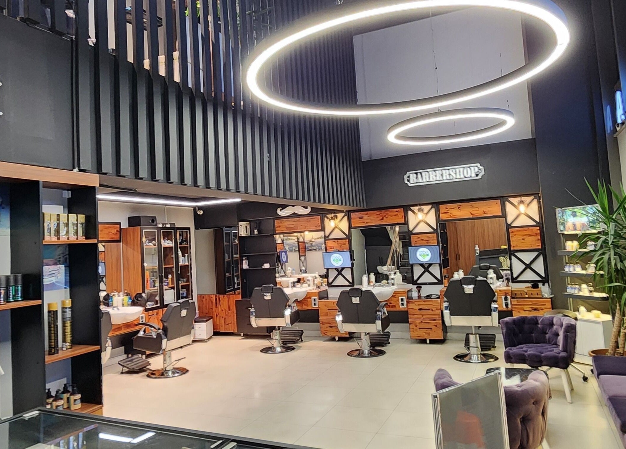 Interior of Alkent Erkek Kuafor in İstanbul, Türkiye showcasing modern barber chairs and elegant decor.