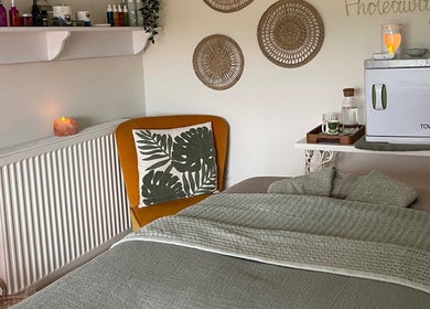 Cozy treatment room at The Holistic Hideaway, Pott Row, England, GB featuring warm decor and a towel warmer.