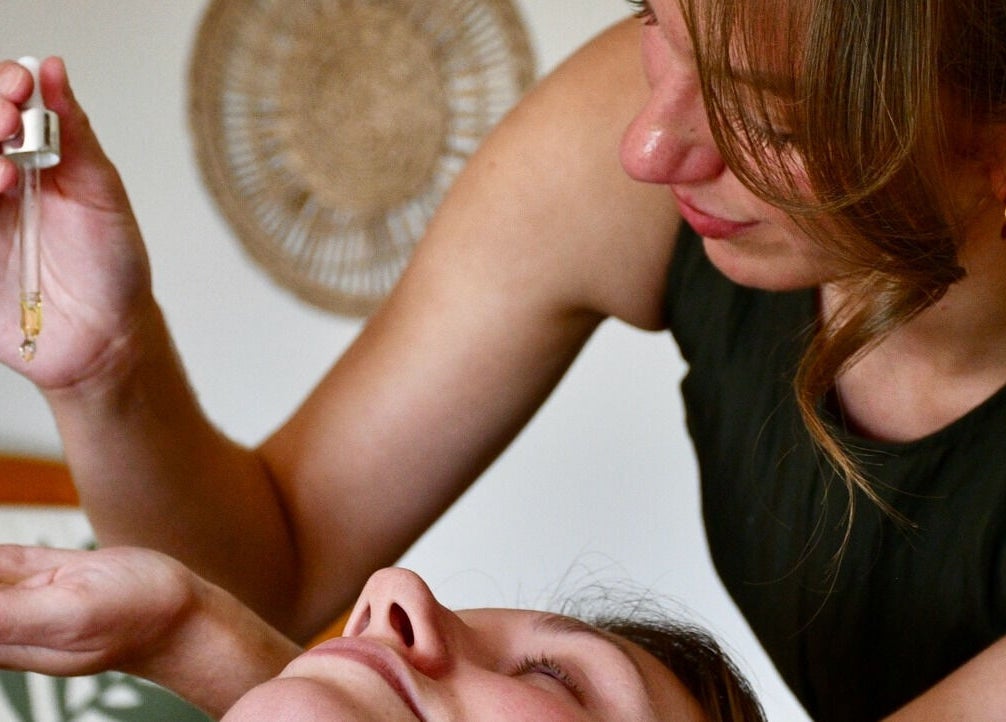 Therapist applying essential oil at The Holistic Hideaway, Pott Row, England, GB for soothing relaxation.