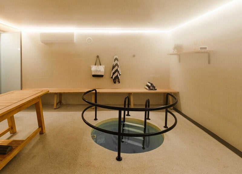 Relaxing spa room at Chimes Day Spa, Denmark, Western Australia, AU featuring wooden benches and a plunge pool.