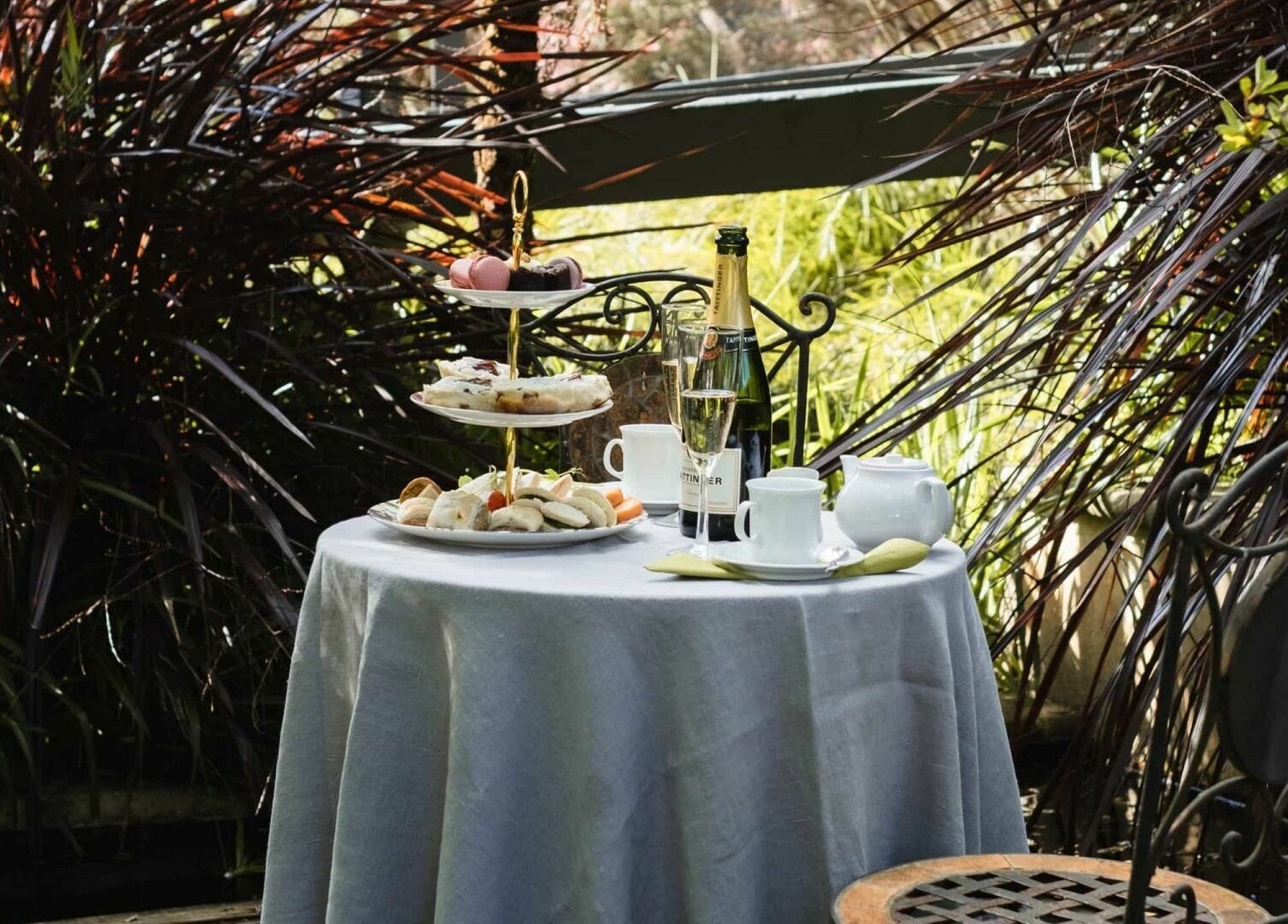 Chimes Day Spa's peaceful garden terrace in Denmark, Western Australia, featuring a serene tea setting with pastries.