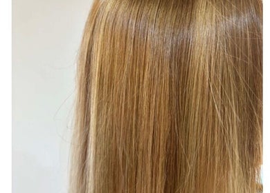 Elegant blonde hair styling at Scarletts Hair in Rochester, England, GB, showcasing smooth, shiny, golden strands.