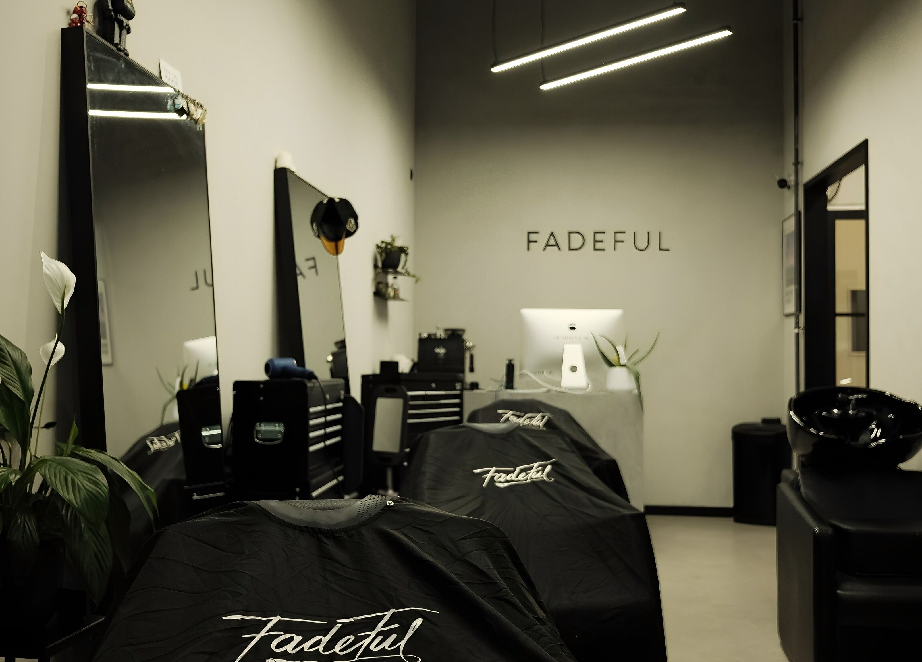 Interior of Fadeful Barbershop in Almere, Flevoland, NL with sleek black decor and professional barber chairs.