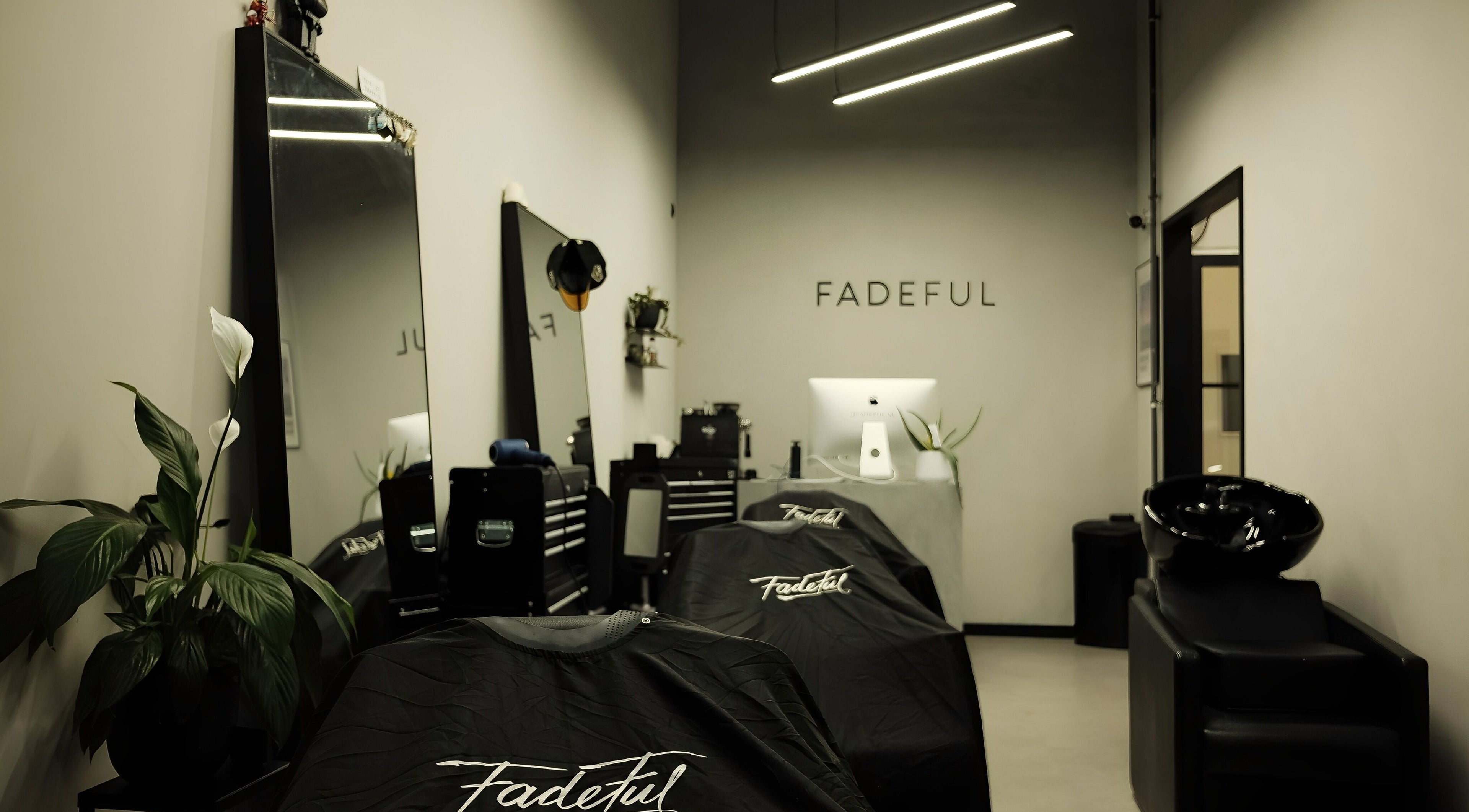 Interior of Fadeful Barbershop in Almere, Flevoland, NL with sleek black decor and professional barber chairs.