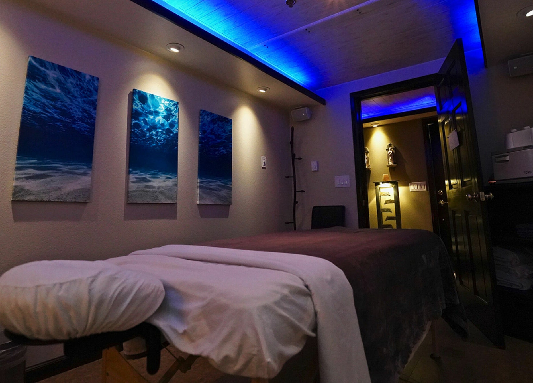 Tranquil massage room at Mt. Royal Spa in Frisco, Colorado, US with ambient lighting and ocean artwork.
