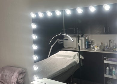 Elegant skincare treatment room at LUXURY SKINCARE STUDIO, Bloomington, Minnesota, US with illuminated mirror.
