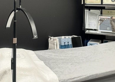 Treatment room at LUXURY SKINCARE STUDIO in Bloomington, Minnesota, US with bed and awards.