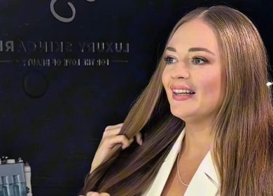 Smiling woman getting styled at Luxury Skincare Studio, Bloomington, Minnesota, US.