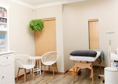 Peaceful therapy room at Dr. Jeanine Cronje Aesthetics in Pretoria, Gauteng, ZA, featuring a massage bed and seating.