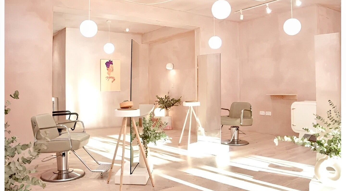 Modern salon interior at Hair by Chris, London, England, GB, featuring sleek chairs and soft lighting.