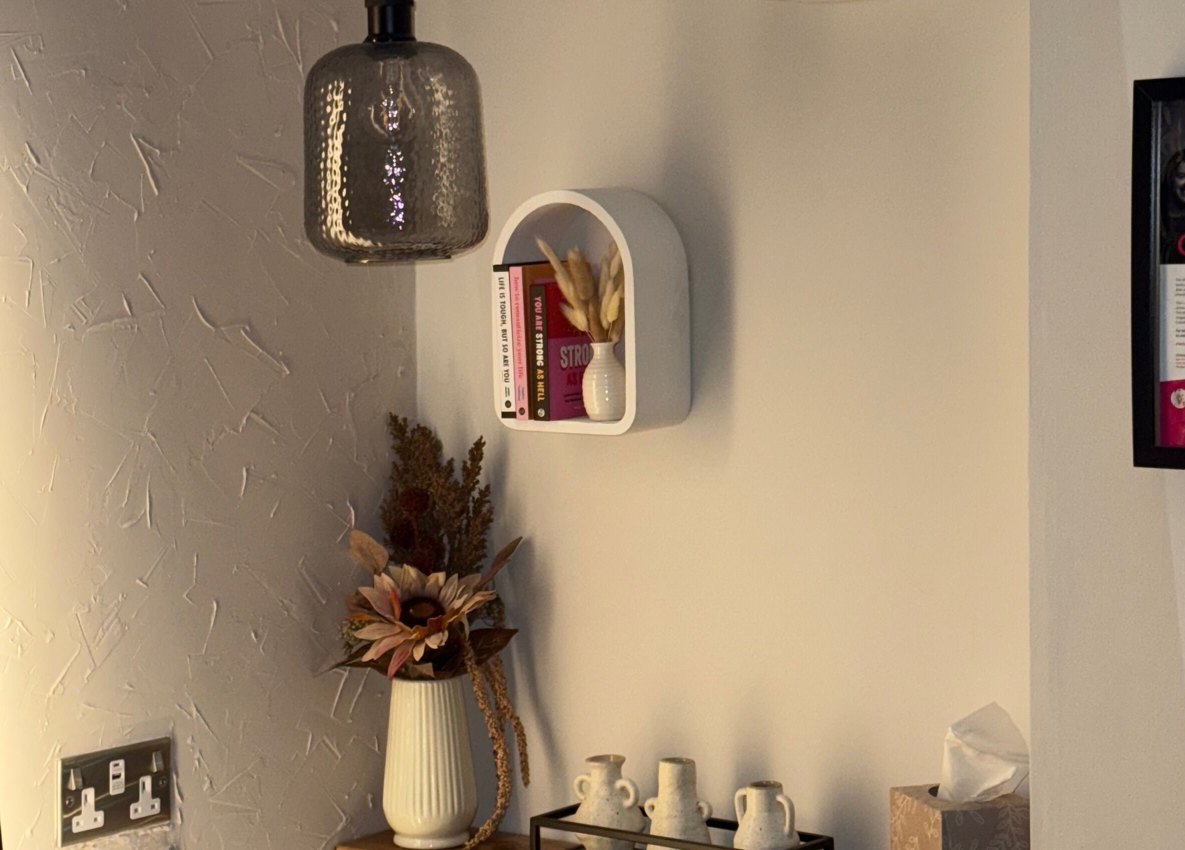 A stylish decor nook at Megan Sutherland Hair in Bathgate, Scotland, GB featuring a vase and books.