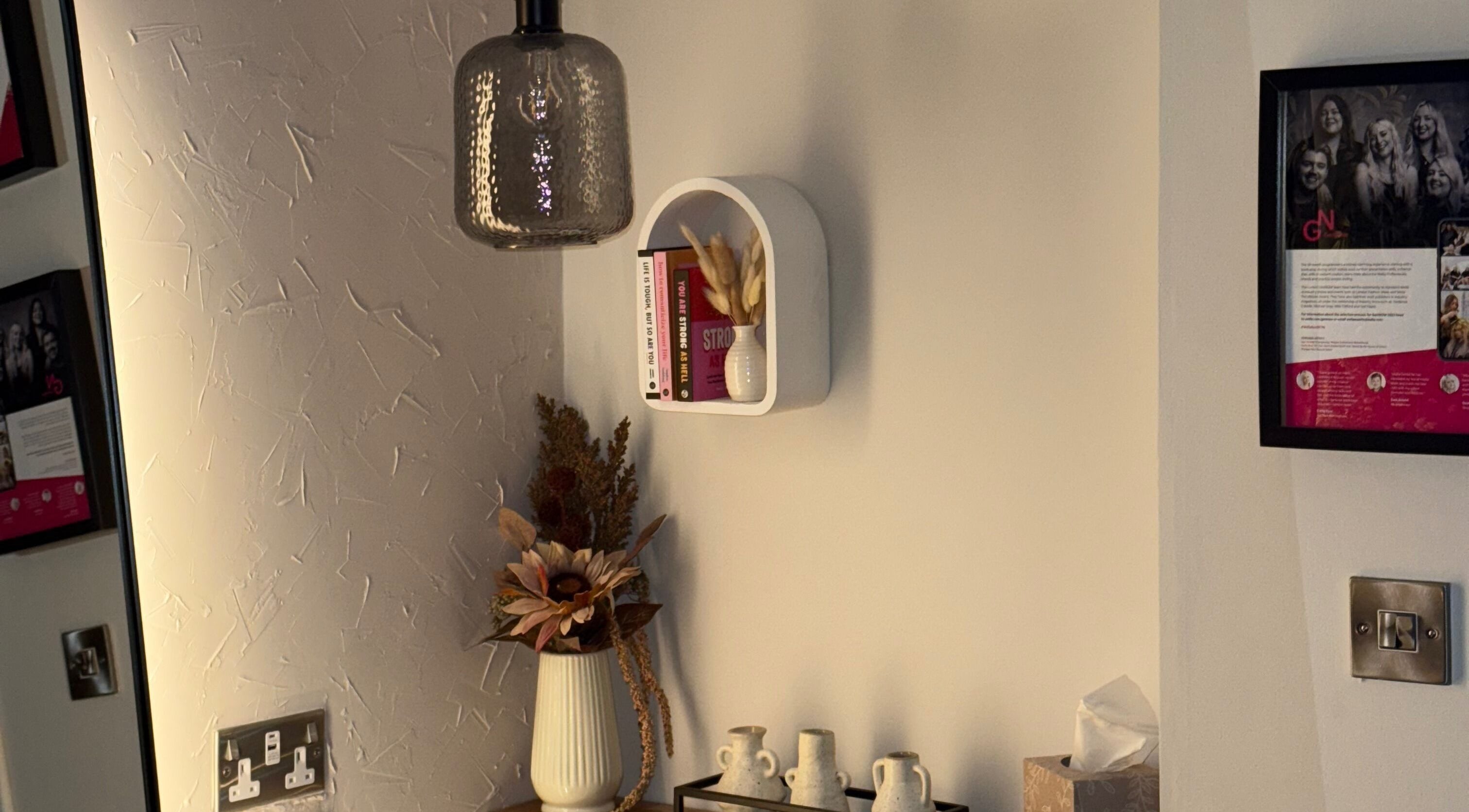 A stylish decor nook at Megan Sutherland Hair in Bathgate, Scotland, GB featuring a vase and books.