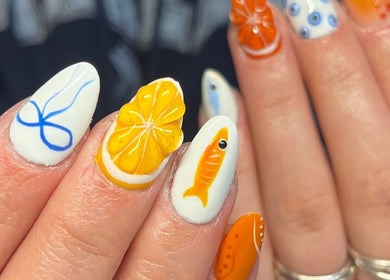 Vibrant nail art with fish and citrus designs at Nails by Kara May in Bridport, England, GB.