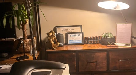 Cozy decor at Nails by Kara May in Bridport, England, GB with certifications and plants on a wooden desk.