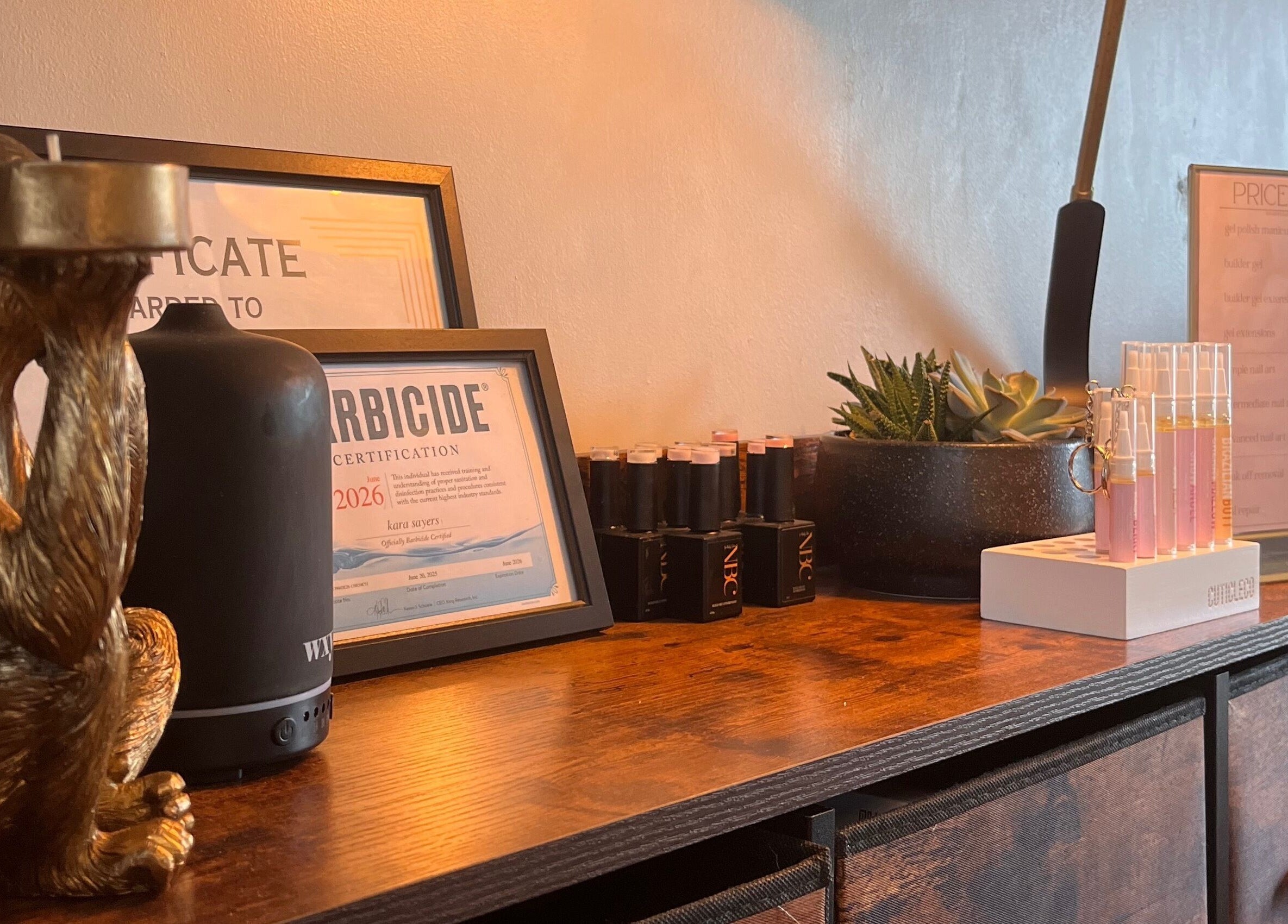 Decorative salon counter at Nails by Kara May in Bridport, England, GB featuring a gold statue and certificates.