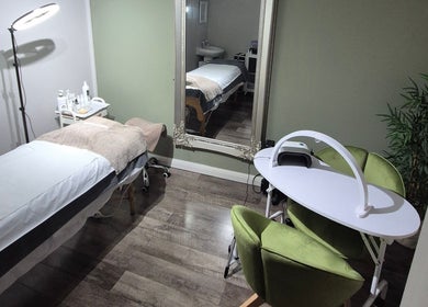 Treatment room at Julia Plas Skin at The House of Hair, Alsager, England, GB, featuring a bed and green chairs.