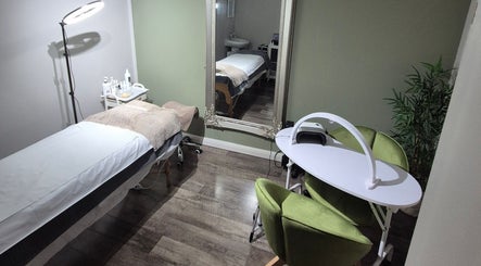 Treatment room at Julia Plas Skin at The House of Hair, Alsager, England, GB, featuring a bed and green chairs.
