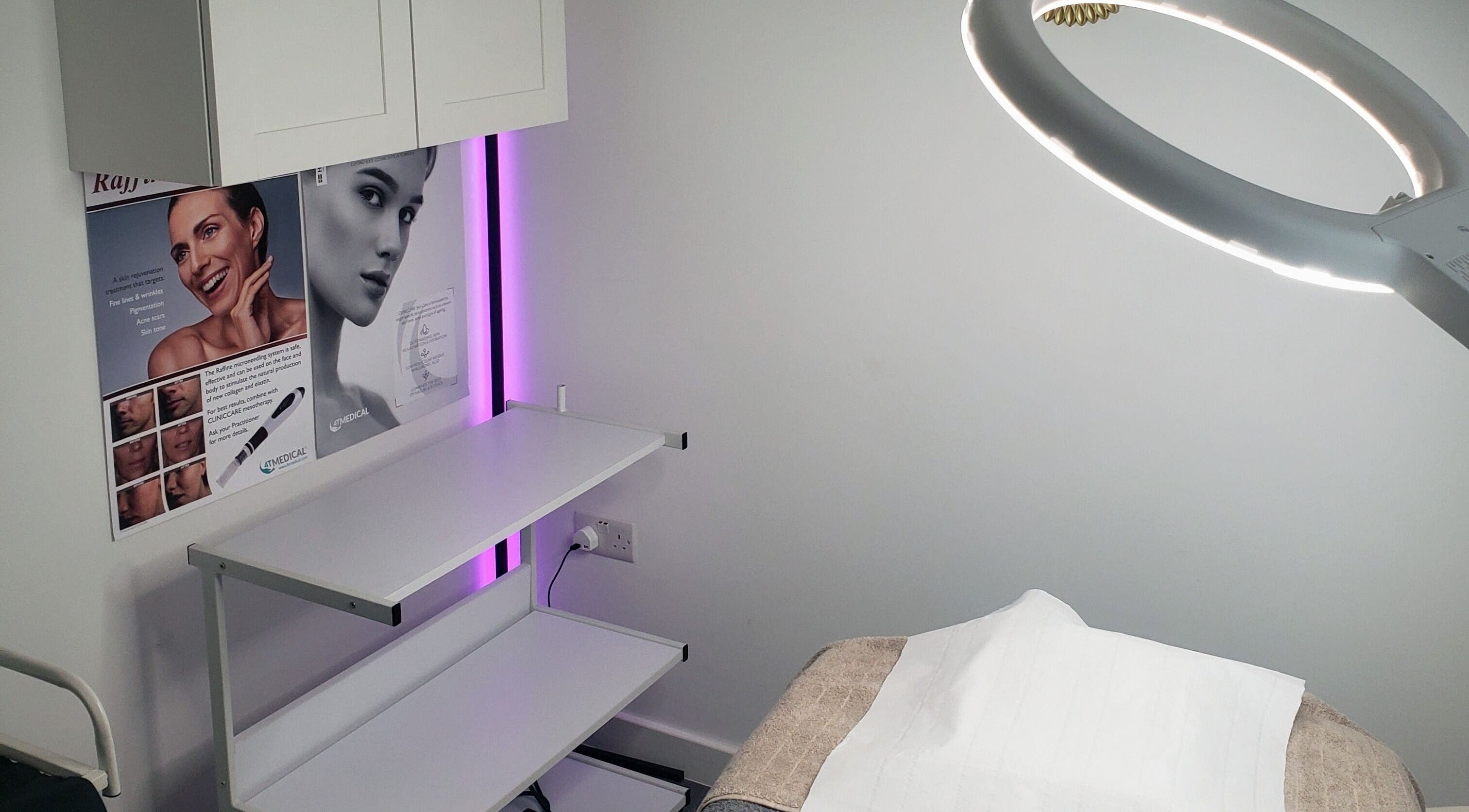 Modern treatment room at Julia Plas Skin Alsager, Stoke-on-Trent, England, GB, featuring a bright lamp and promotional posters.