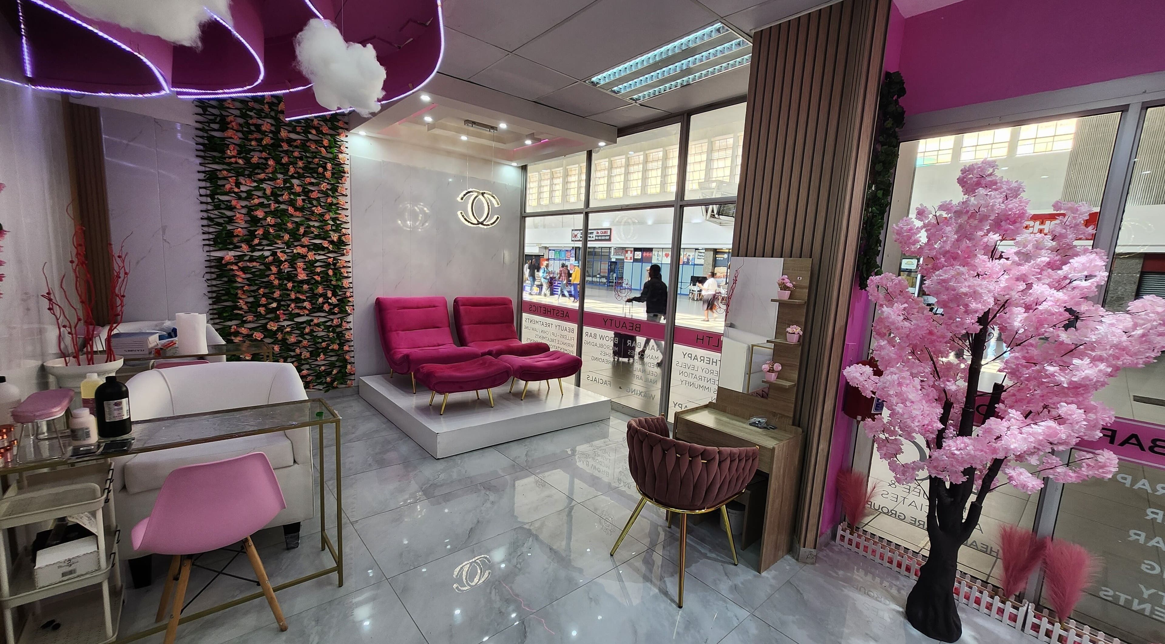 Elegant Beauty Bar interior in Johannesburg, Gauteng, ZA, featuring plush pink seating and floral decor.